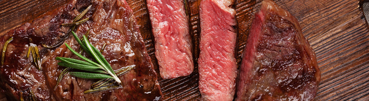 Carne vermelha mal passada em uma superfície de madeira