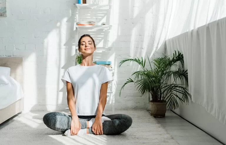Mulher sentada no chão em posição de meditação