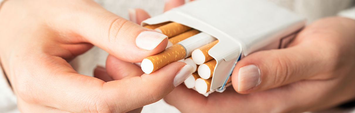 Pessoa pegando um cigarro de um maço